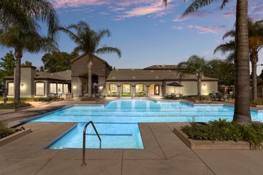 Poolside lounge chairs beside a resort pool at sunset Sequoia West Coast Multifamily Property Management.