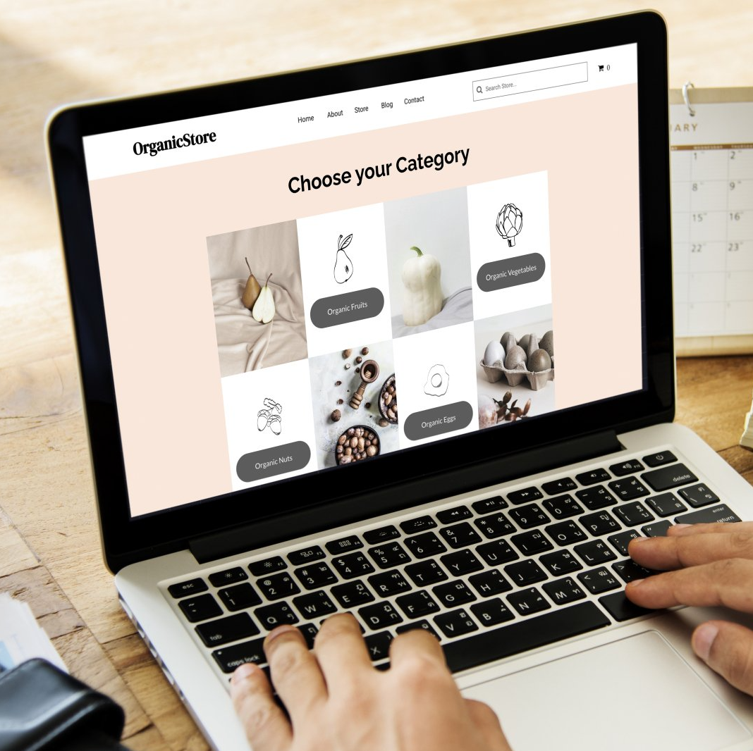 Hands typing on a laptop displaying a “Choose your Category” webpage with product tiles.