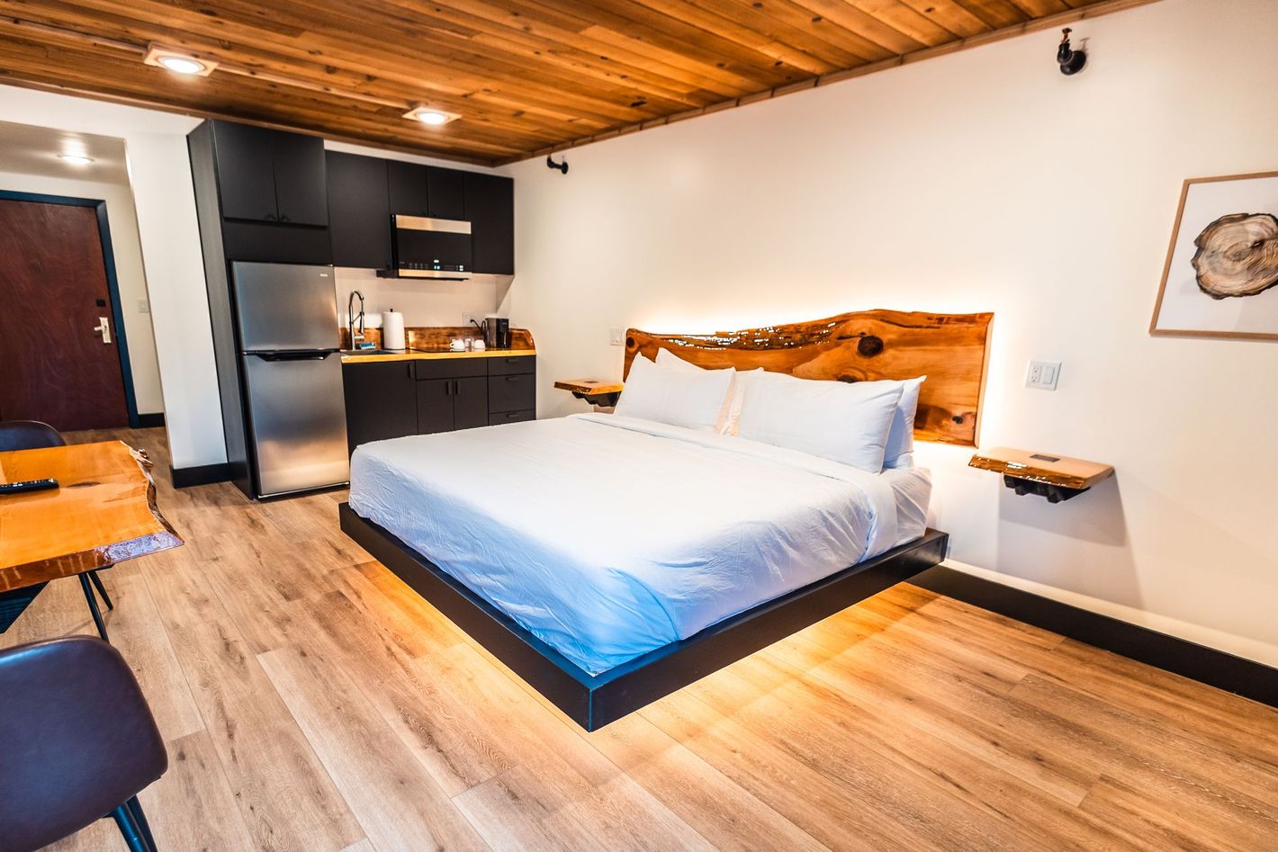 A hotel room with a king size bed and a kitchen.