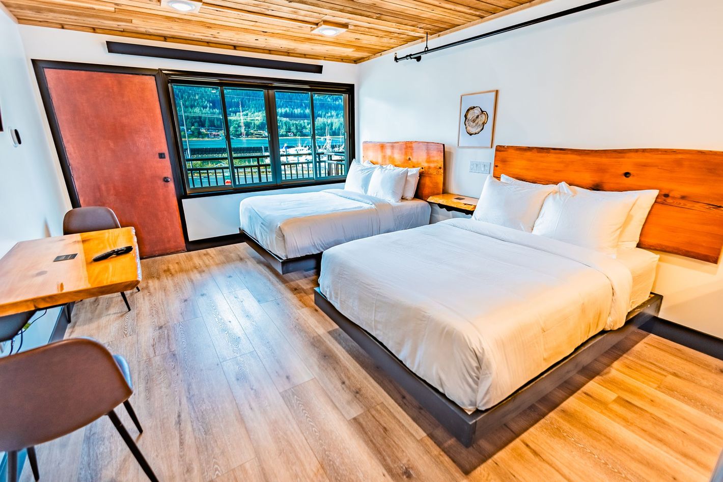 A hotel room with two beds , a table and chairs.