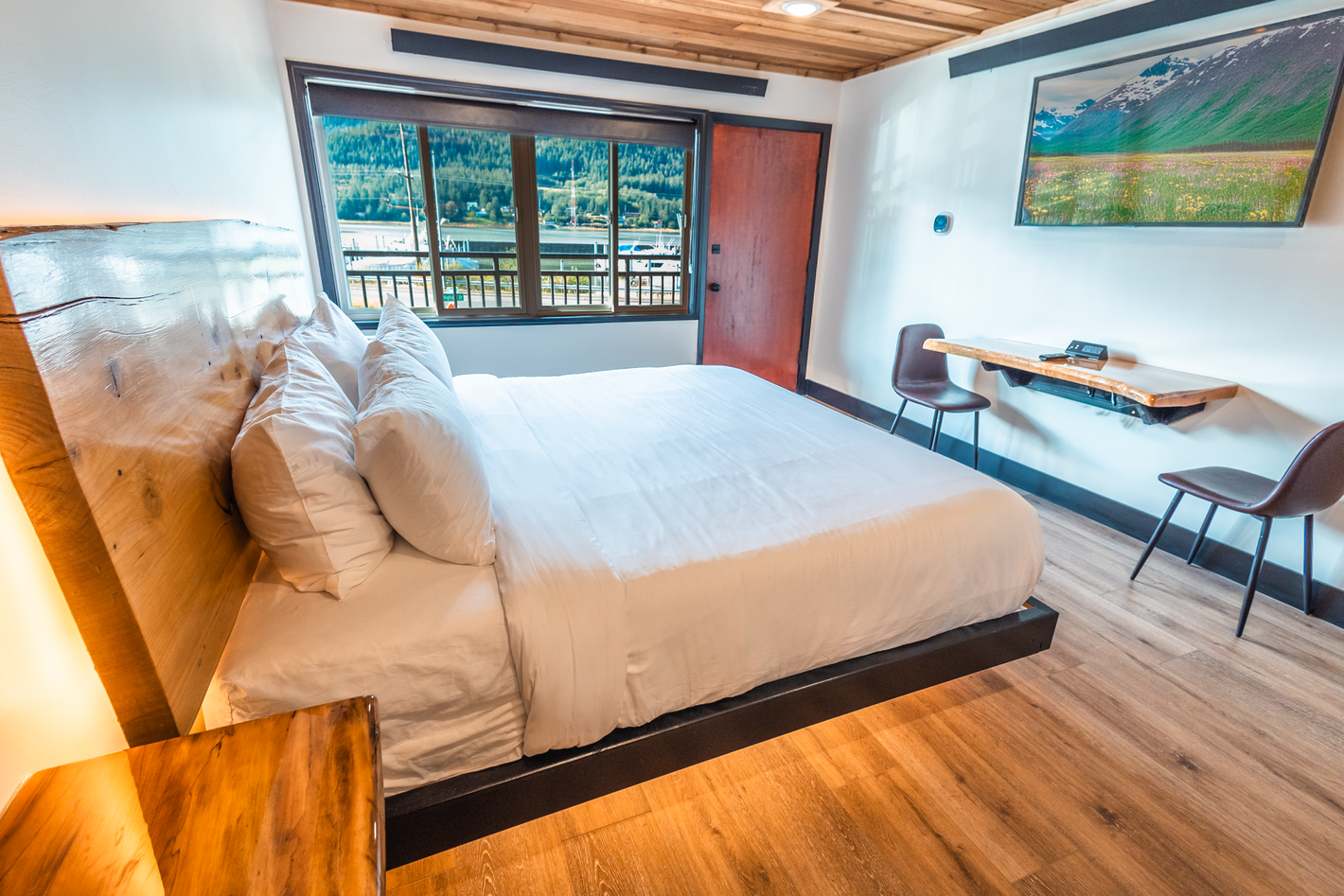 A hotel room with a large bed , desk and chairs.