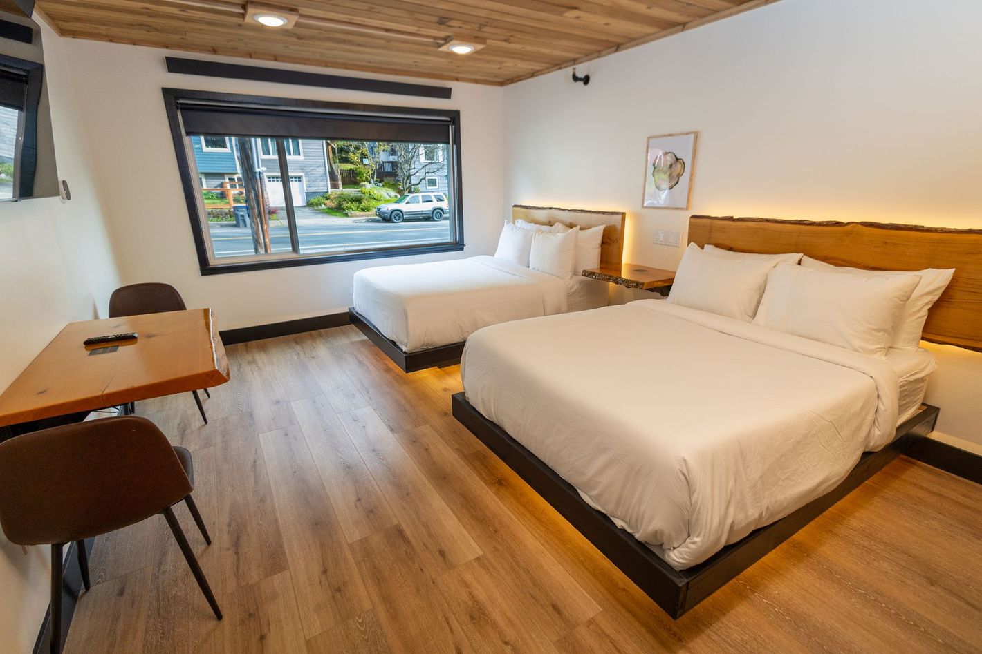 A hotel room with two beds , a table and chairs.