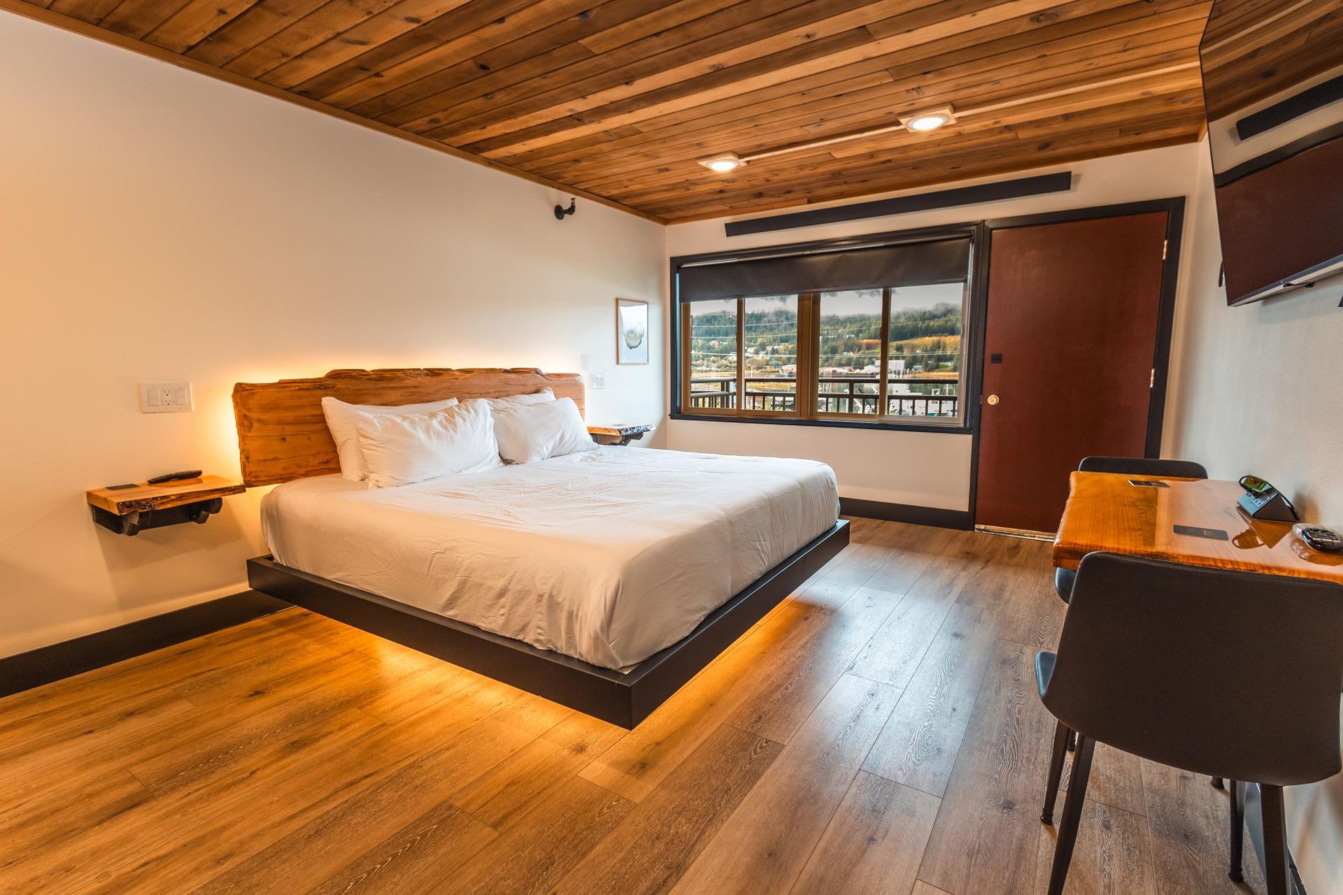 A hotel room with a king size bed and a desk.