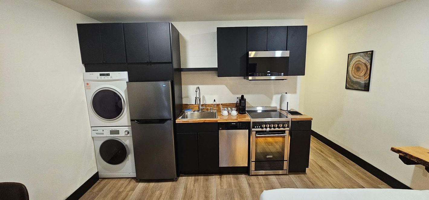 A kitchen with a washer and dryer stacked on top of each other.