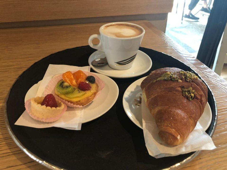 Colazione con croissant, pasticcini e cappuccino