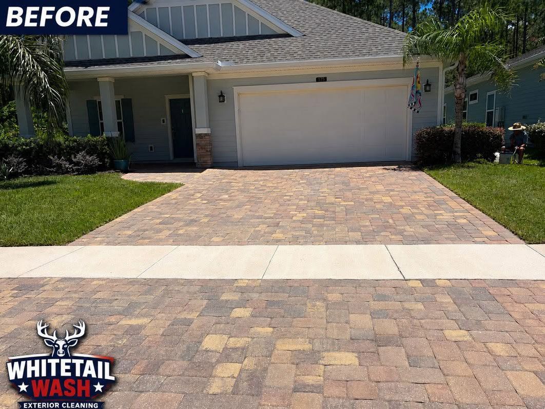 Before photo of a suburban house with a tan paver driveway and garage.