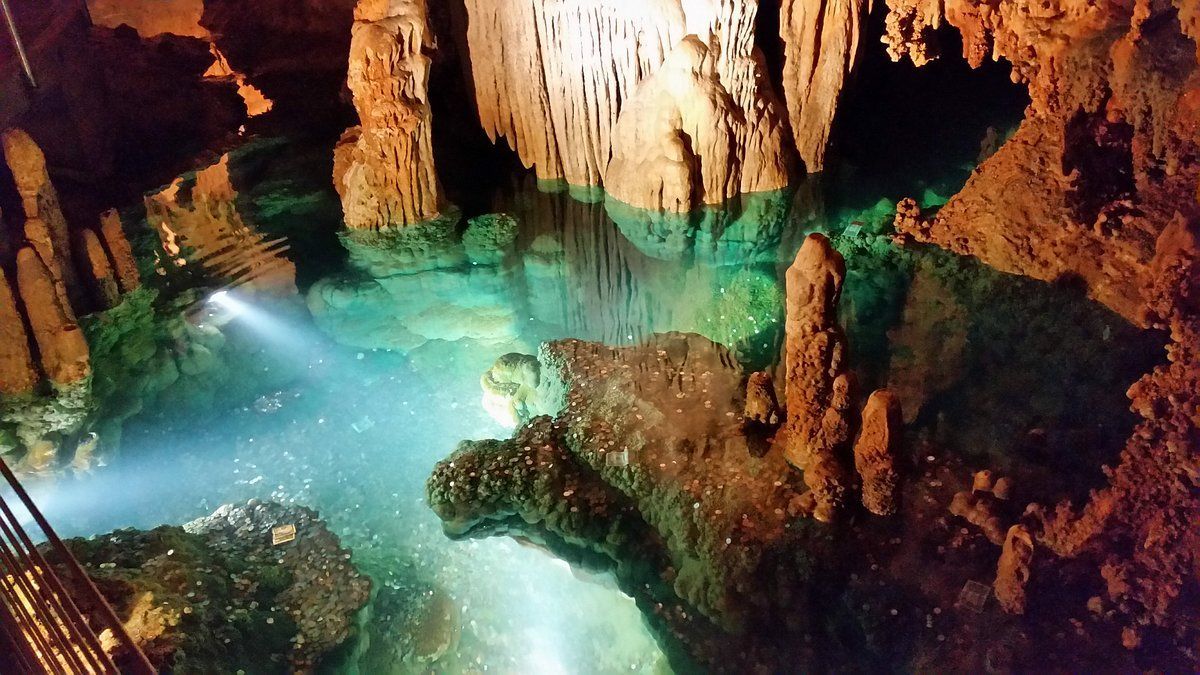 A light is shining on a pool of water in a cave.