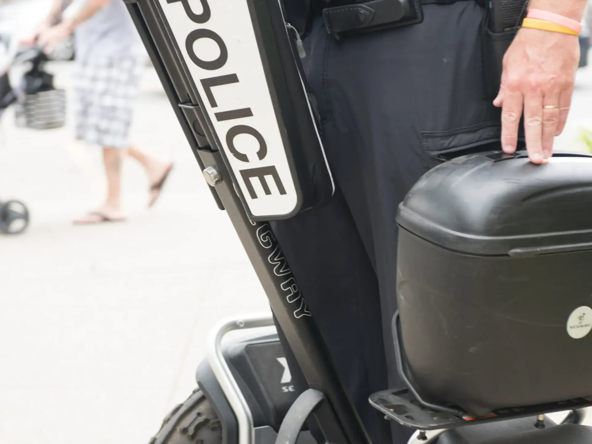 Police officer holding a black suitcase beside a police vehicle