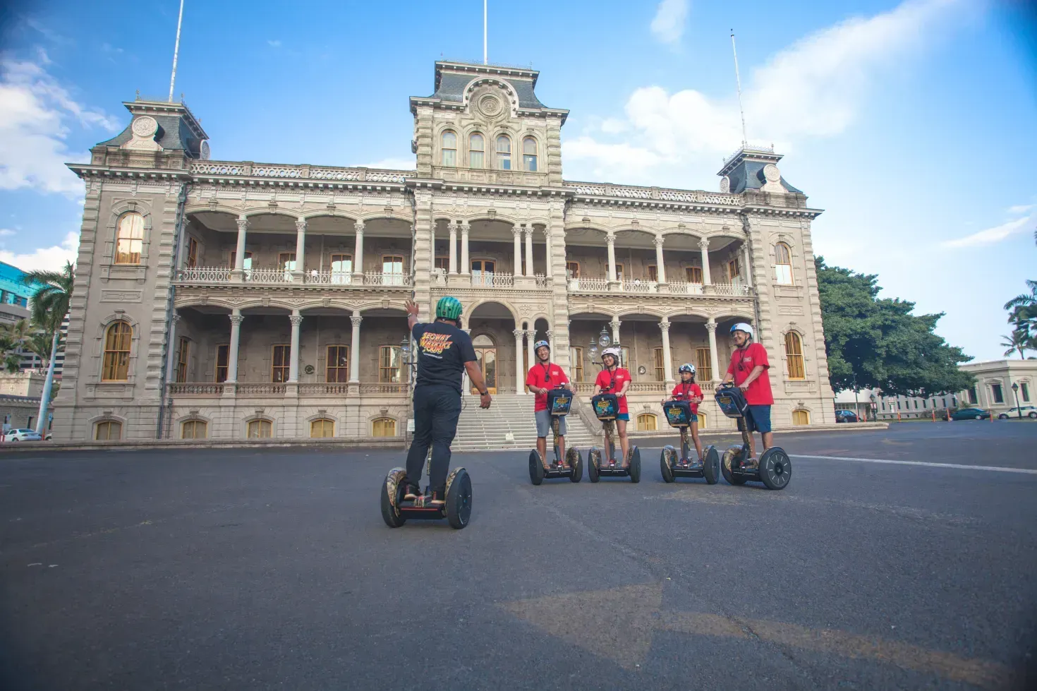 People on Segways in front of a grand historic building on a sunny day
