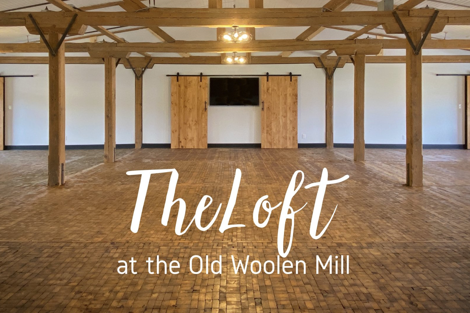 The loft at the old woolen mill is a large empty room with wooden beams.