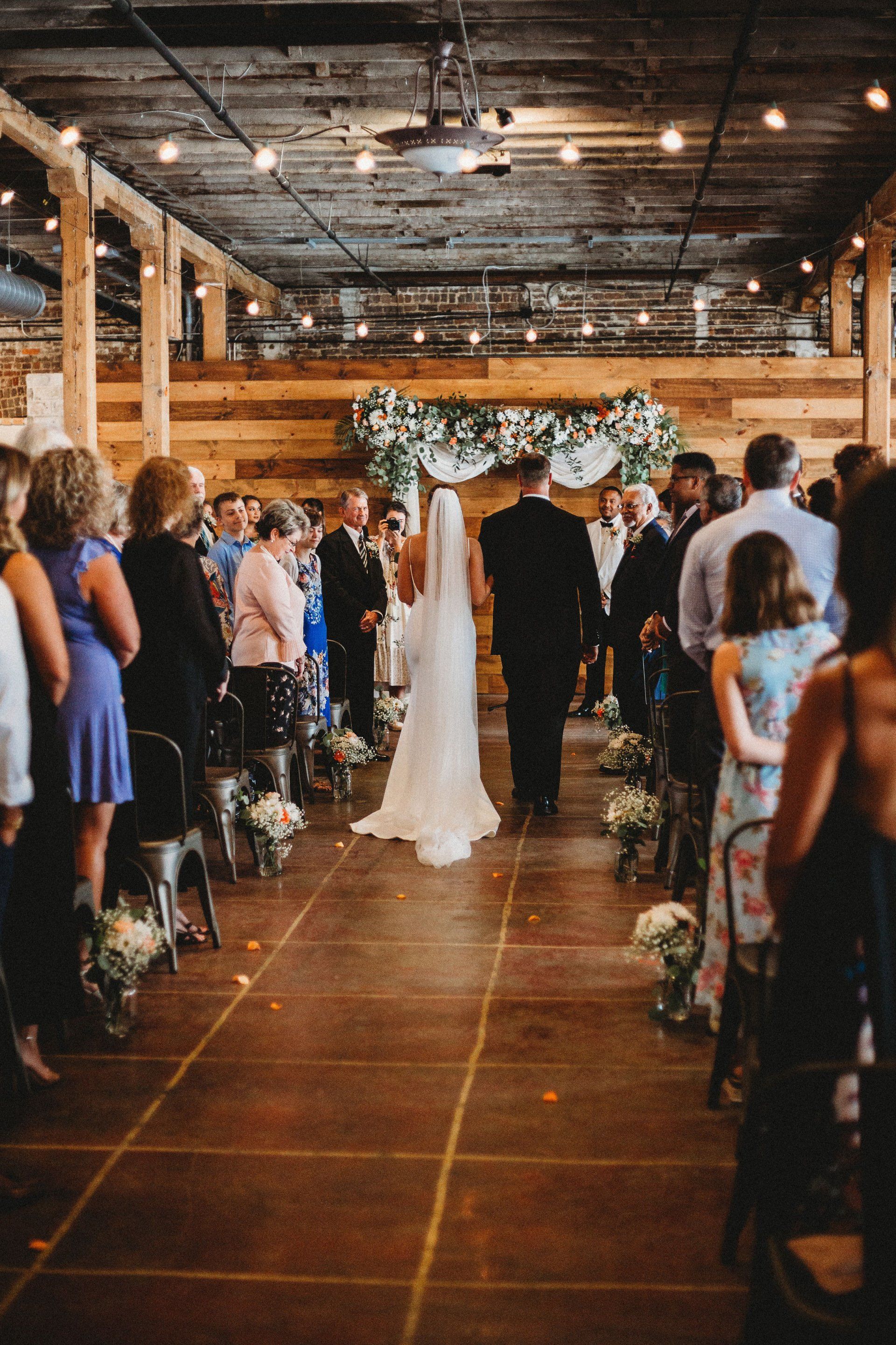 A bride and groom are walking down the aisle at their wedding ceremony.