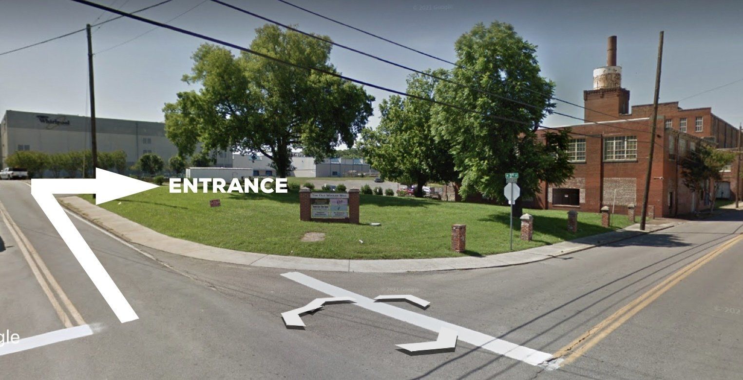 A street corner with an arrow pointing to the entrance