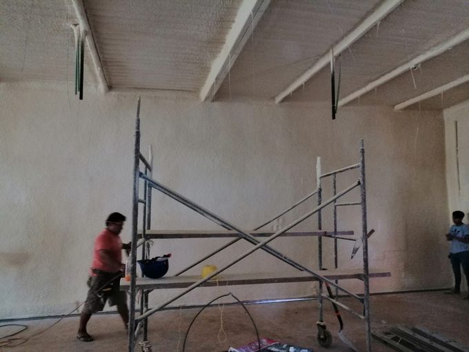 Equipo aplicando aislamiento térmico con poliuretano en nave industrial moderna en México