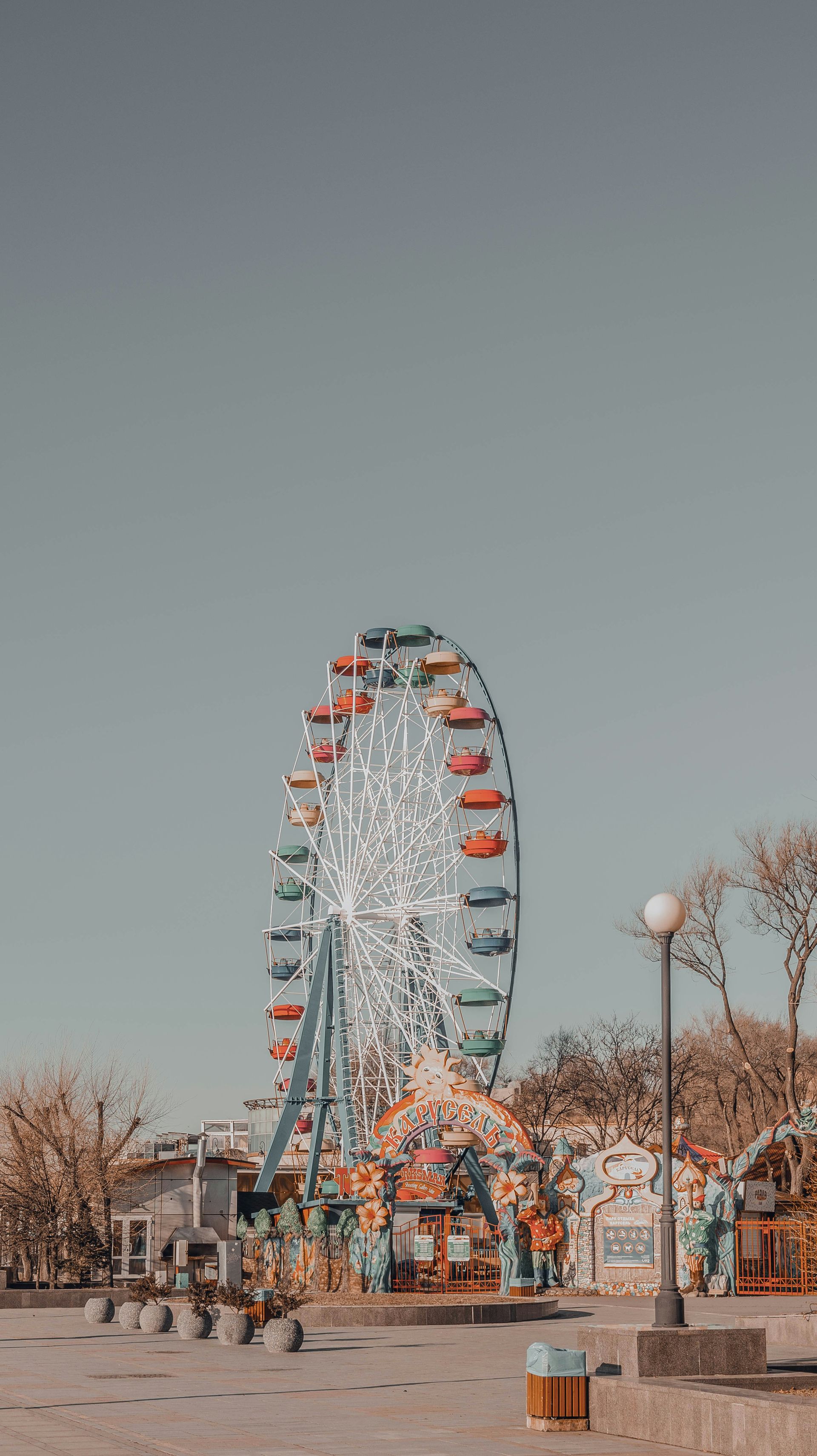 Ferris wheel at an amusement park against a light blue sky.