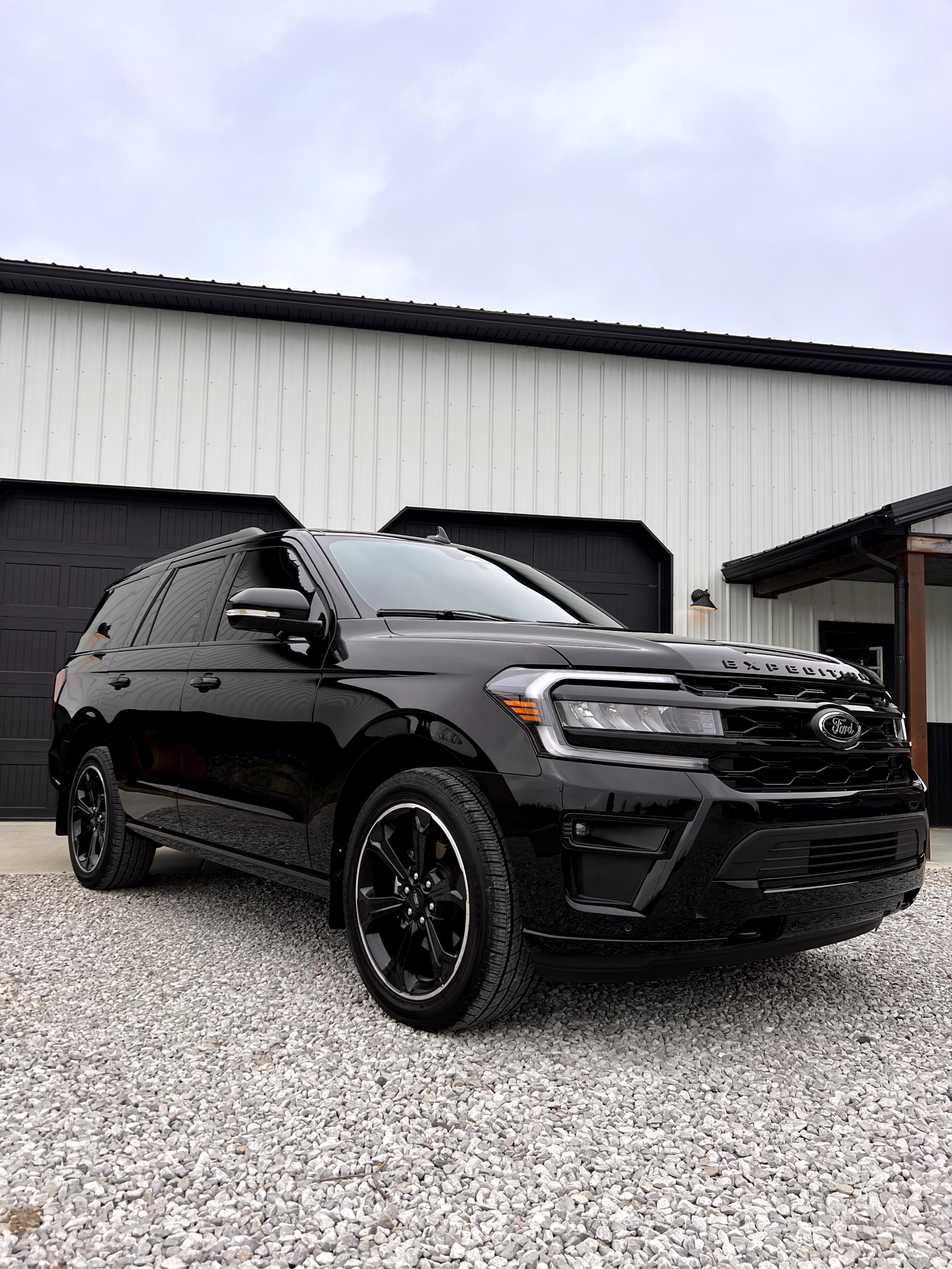 A black suv is parked in front of a garage.