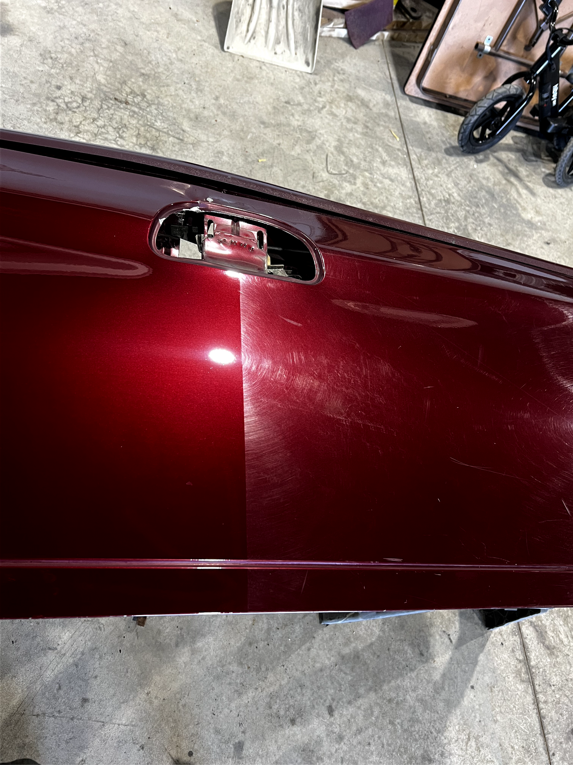 A close up of a red car door in a garage.