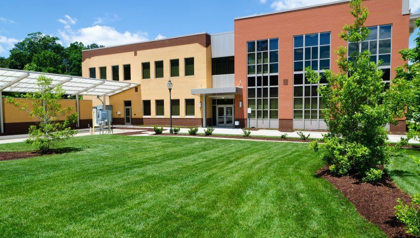 A large building with a lush green lawn in front of it
