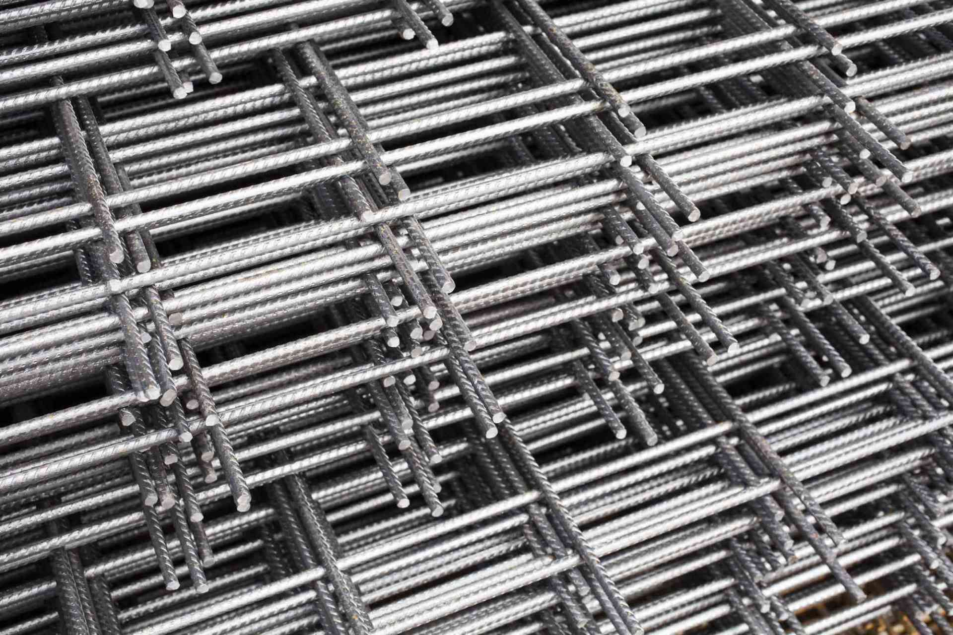 Pannelli di rete metallica impilati che formano un motivo a griglia industriale ripetitivo.