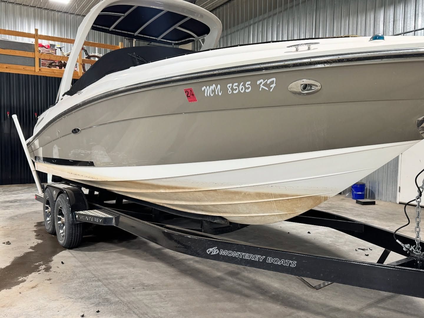 White and gray speedboat on a trailer inside a covered warehouse