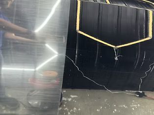 Cracked black cabinet or screen with gold trim beside a reflective metal shelf