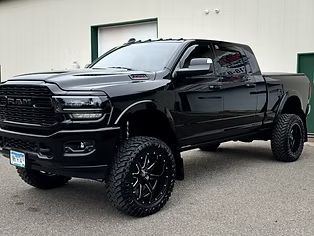 Black lifted pickup truck parked outside a building