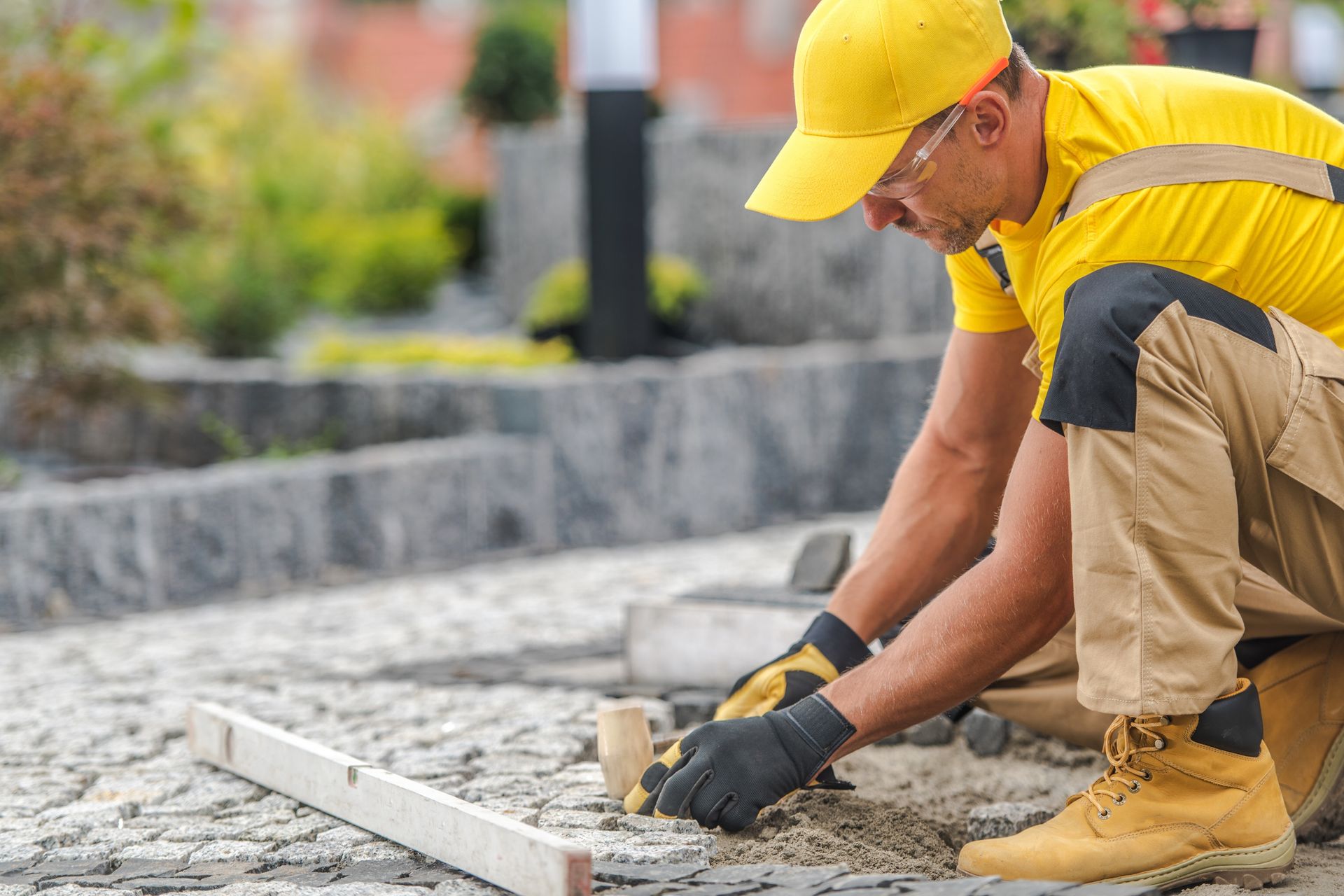 Residential paving contractor installing stone pavers on a walkway