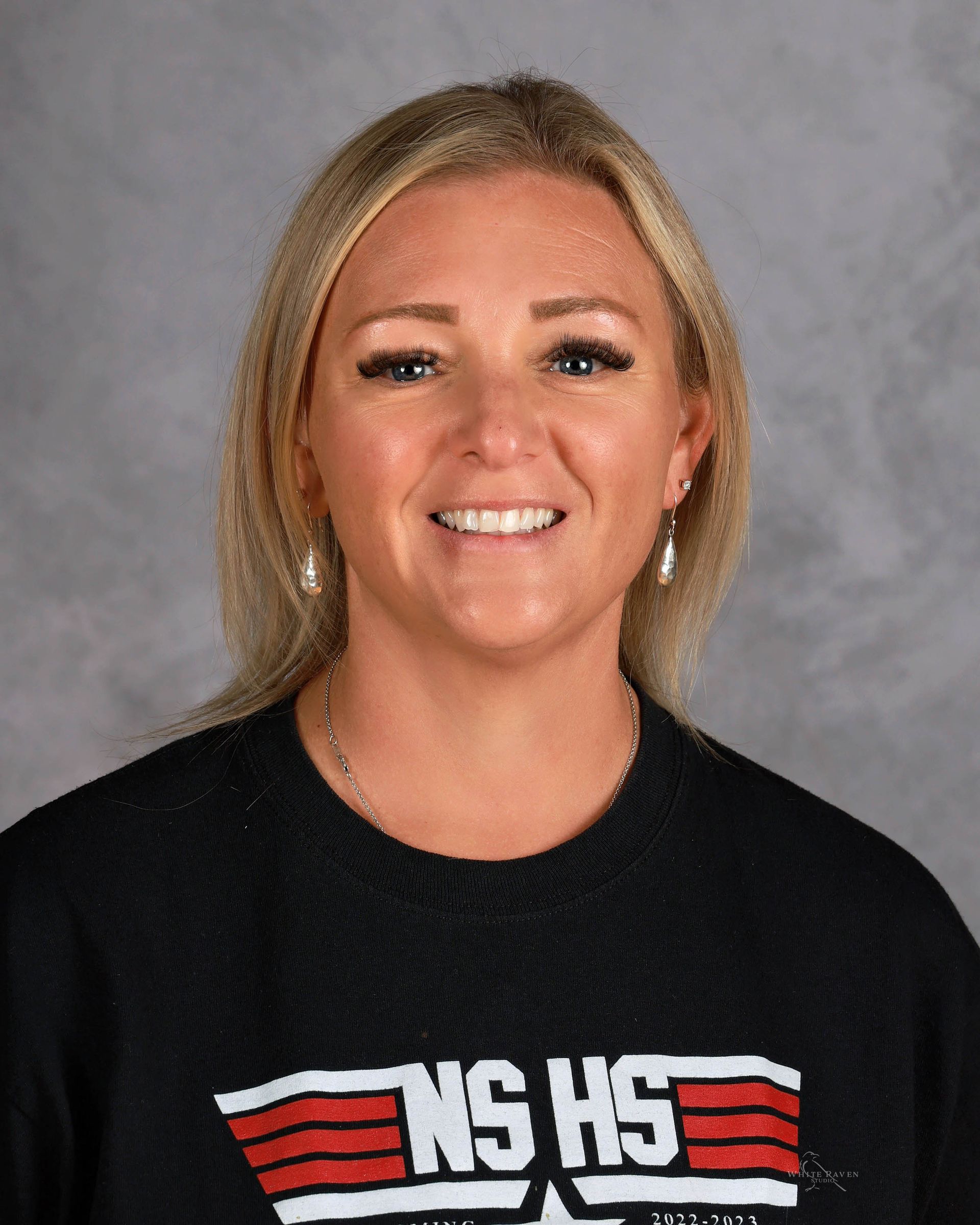 Woman with blonde hair, wearing black shirt with 