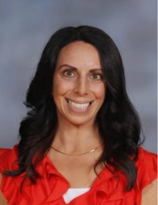 Portrait of a smiling woman with long dark hair in a red blouse against a gray background