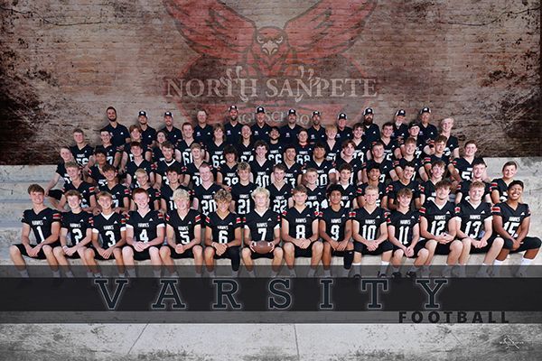 North Sanford Varsity football team group photo in black uniforms against a brick wall mural