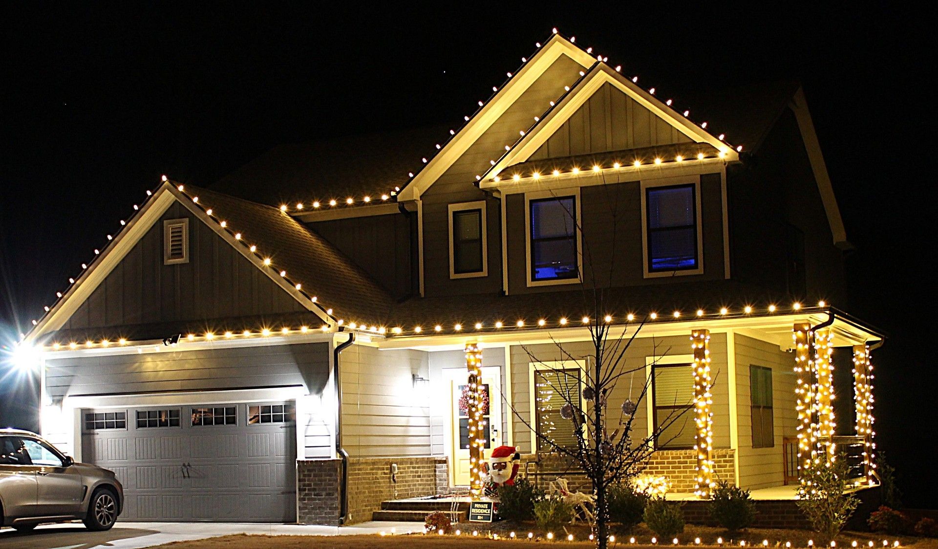 Warm white permanent lighting outlining a two-story home