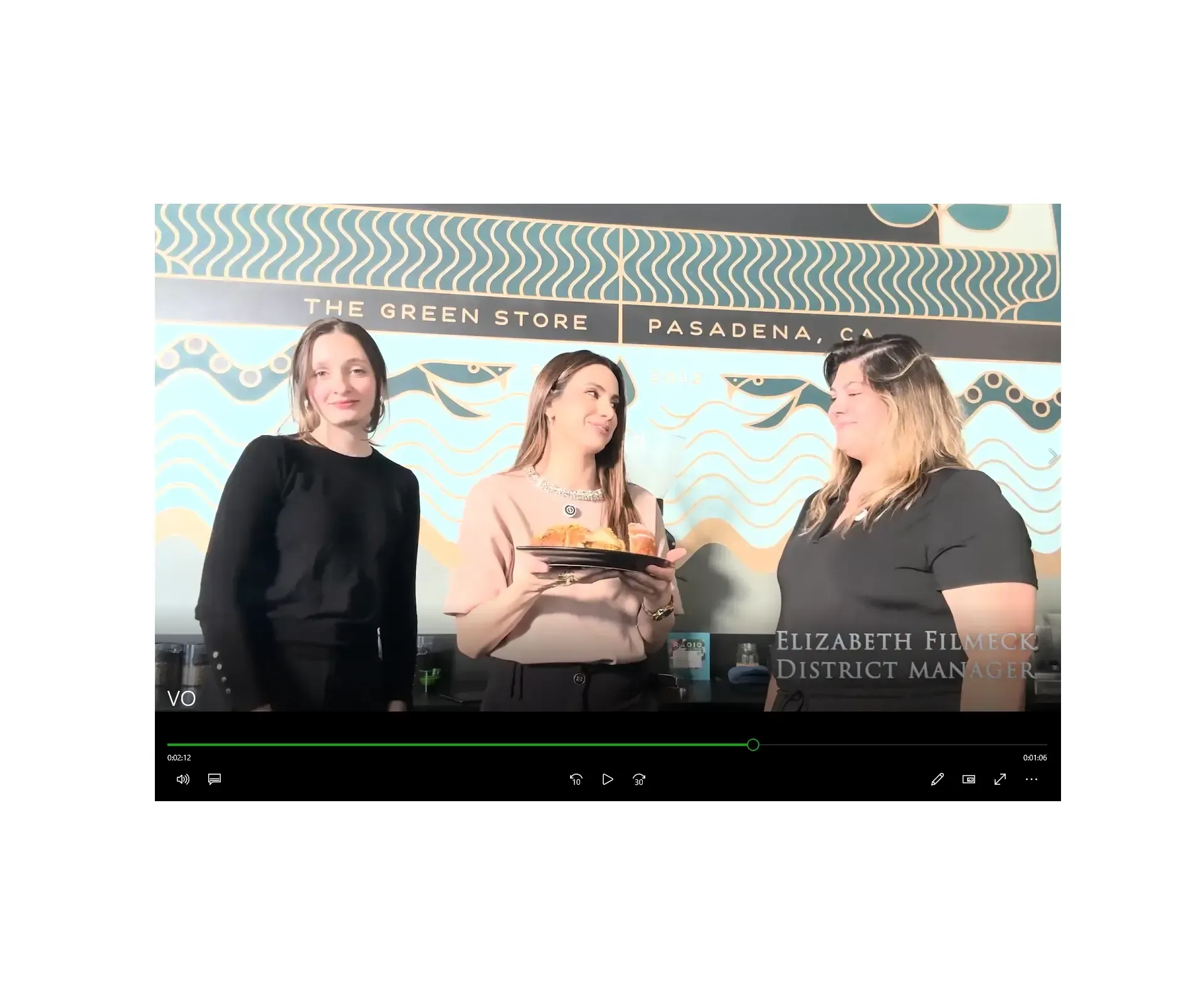 Three women at a coffee shop in Pasadena. One holds a plate of food. Black, tan, green wall.