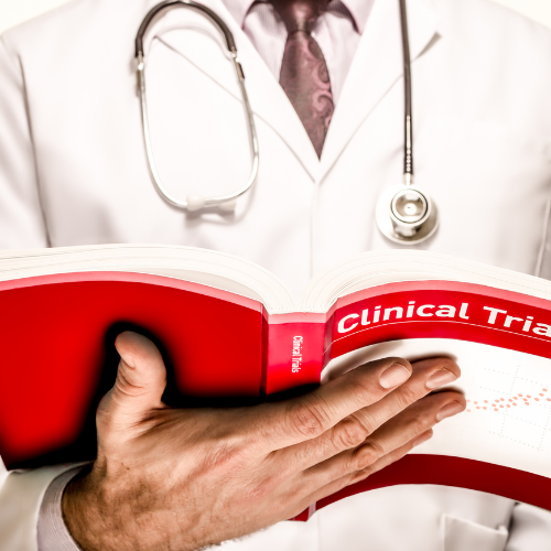 A person in a white lab coat and stethoscope holds an open book with 