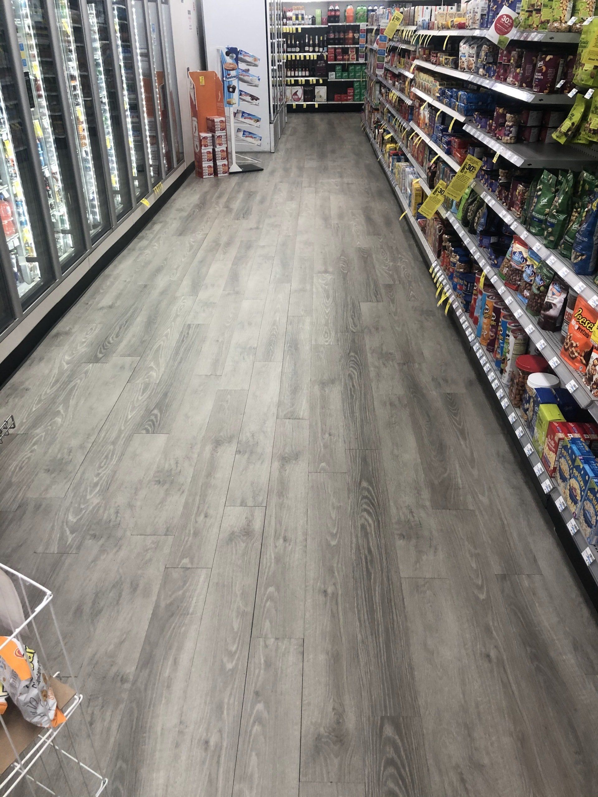 A long aisle in a grocery store with lots of shelves