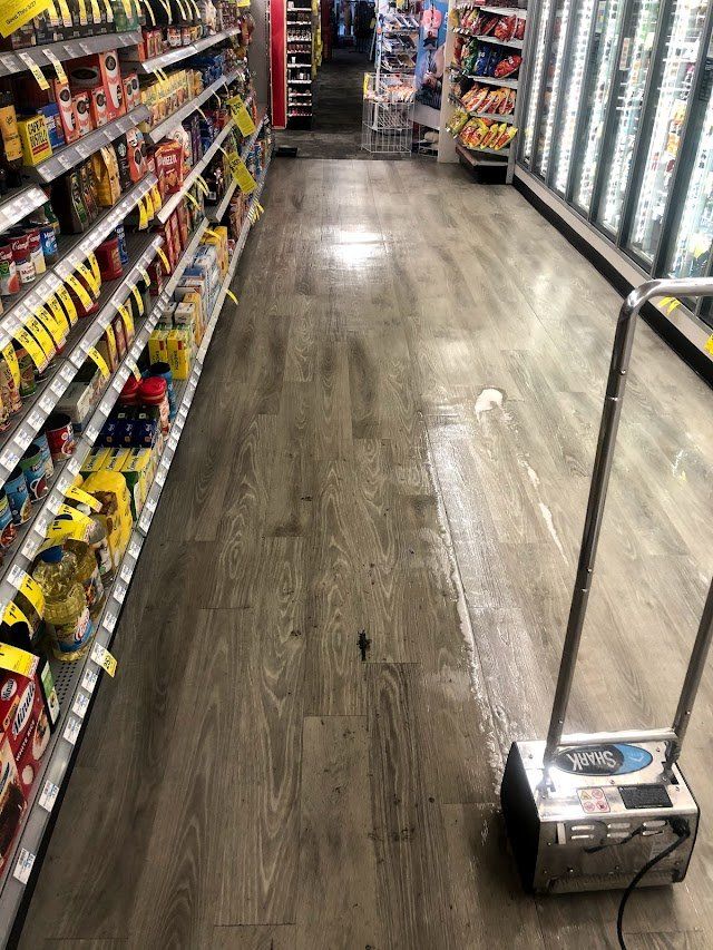 A vacuum cleaner is cleaning the floor of a grocery store.