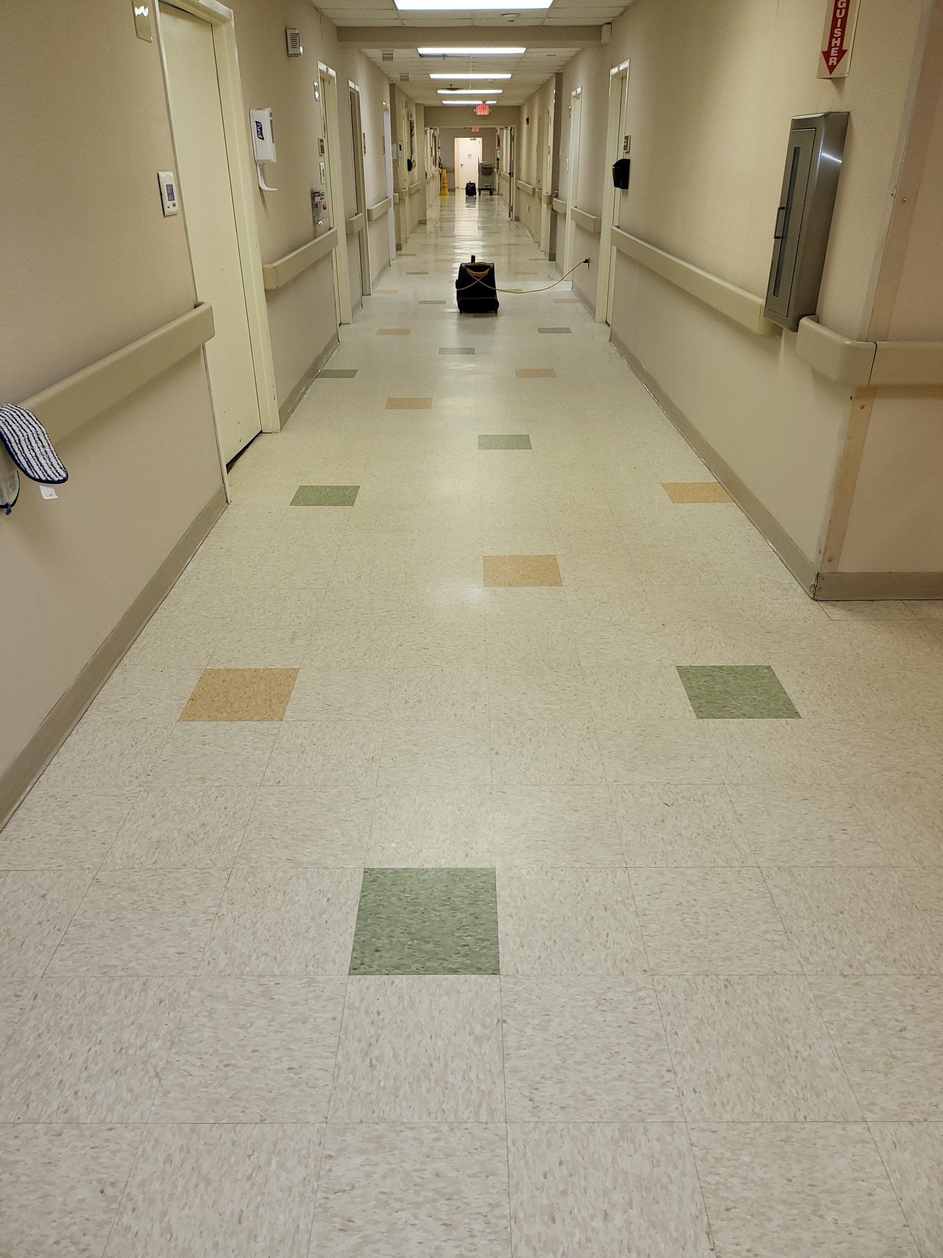 A hospital hallway with a suitcase on the floor