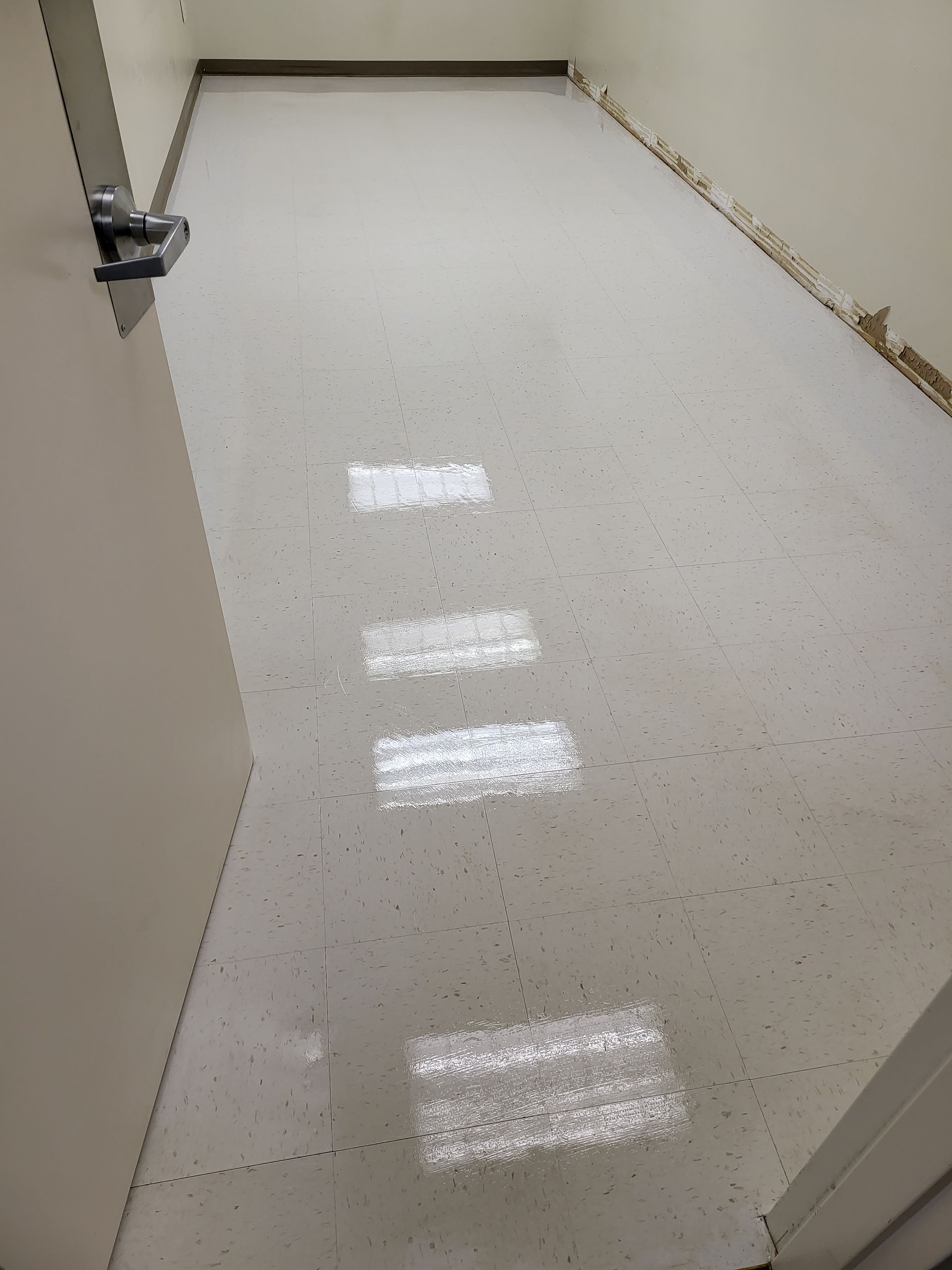 A room with a white tile floor and a door.
