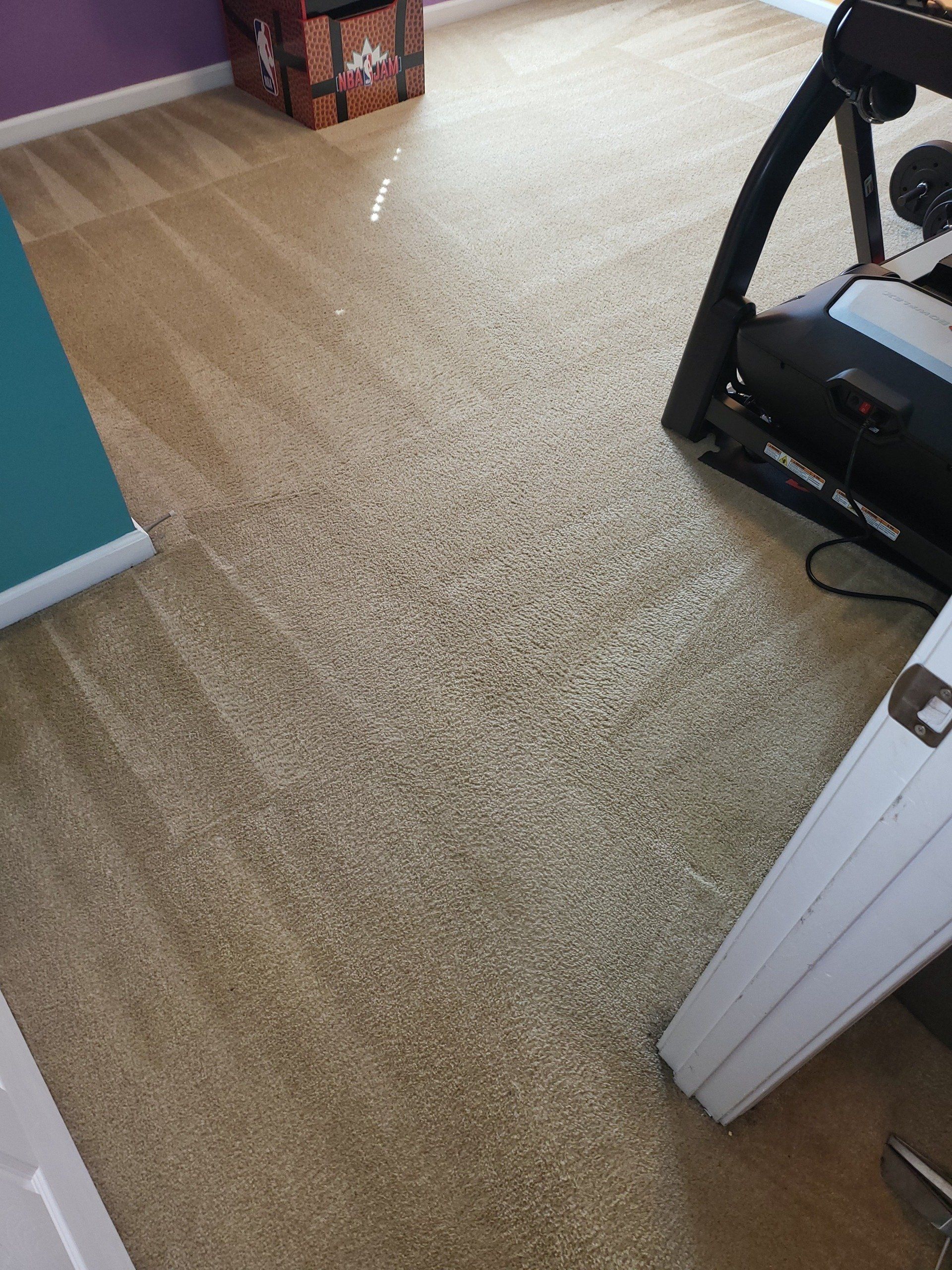 A treadmill is sitting on a carpeted floor in a room.