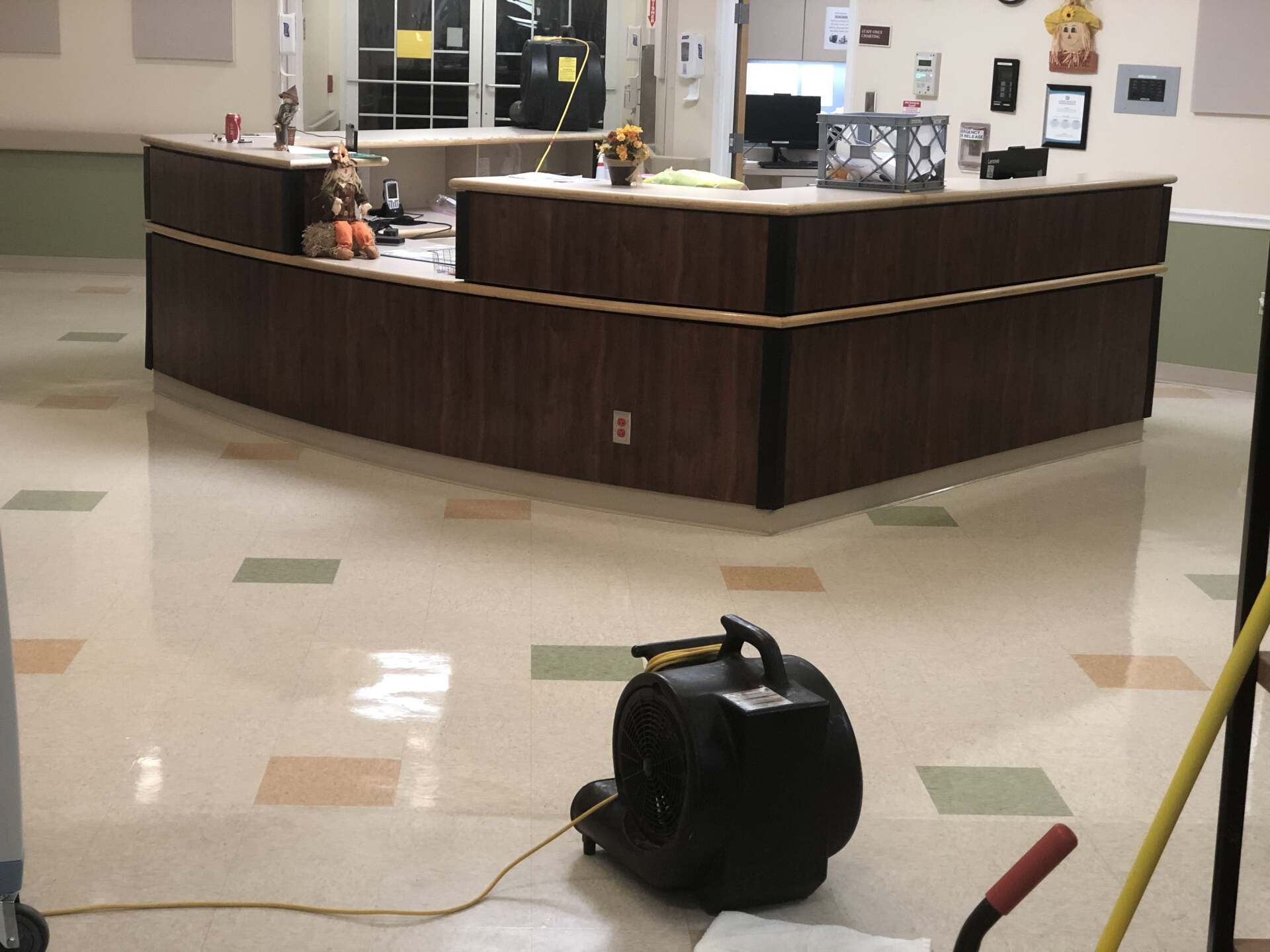 A vacuum cleaner is sitting on the floor in front of a reception desk