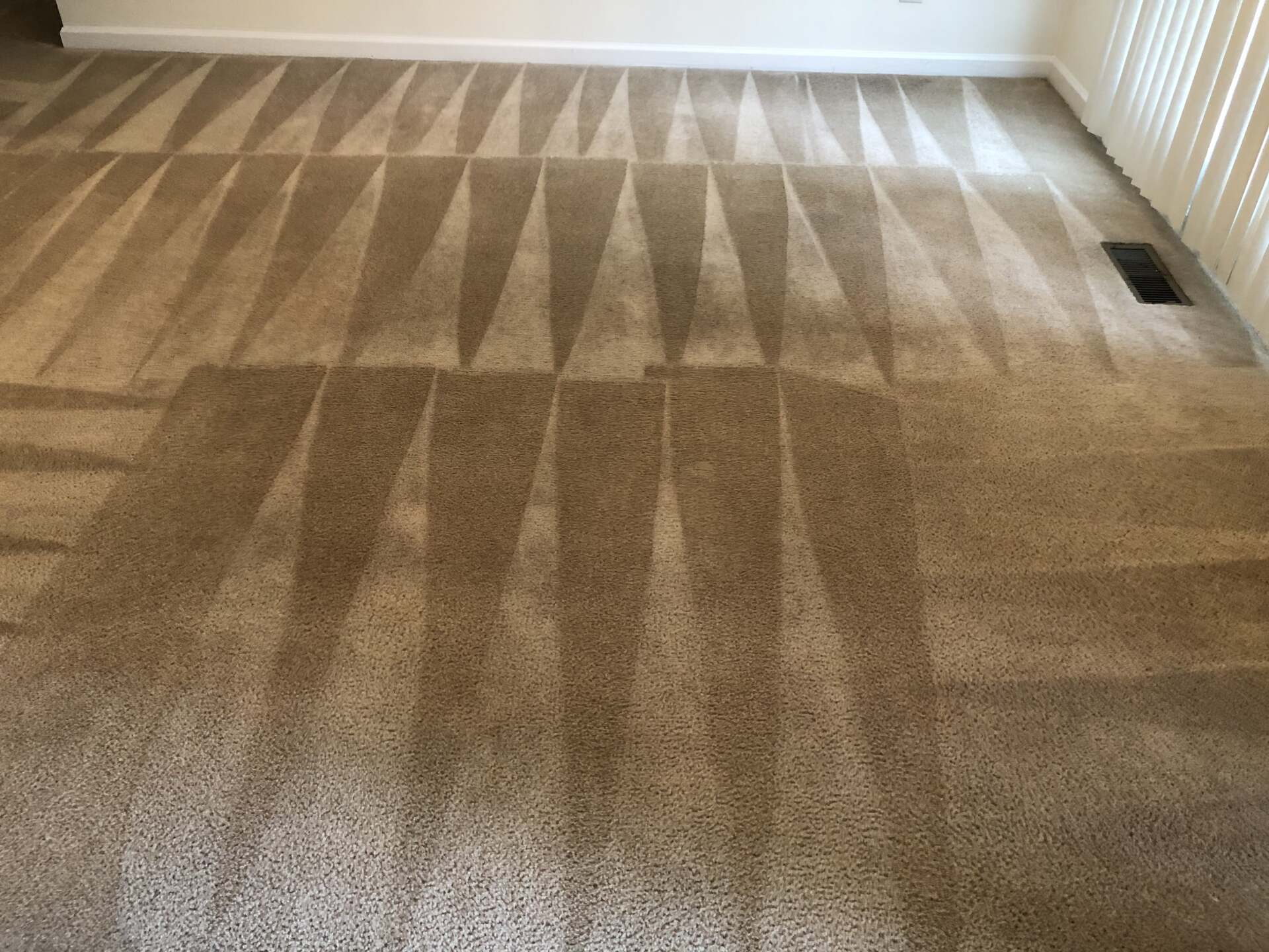 A carpeted floor in a living room with a geometric pattern.