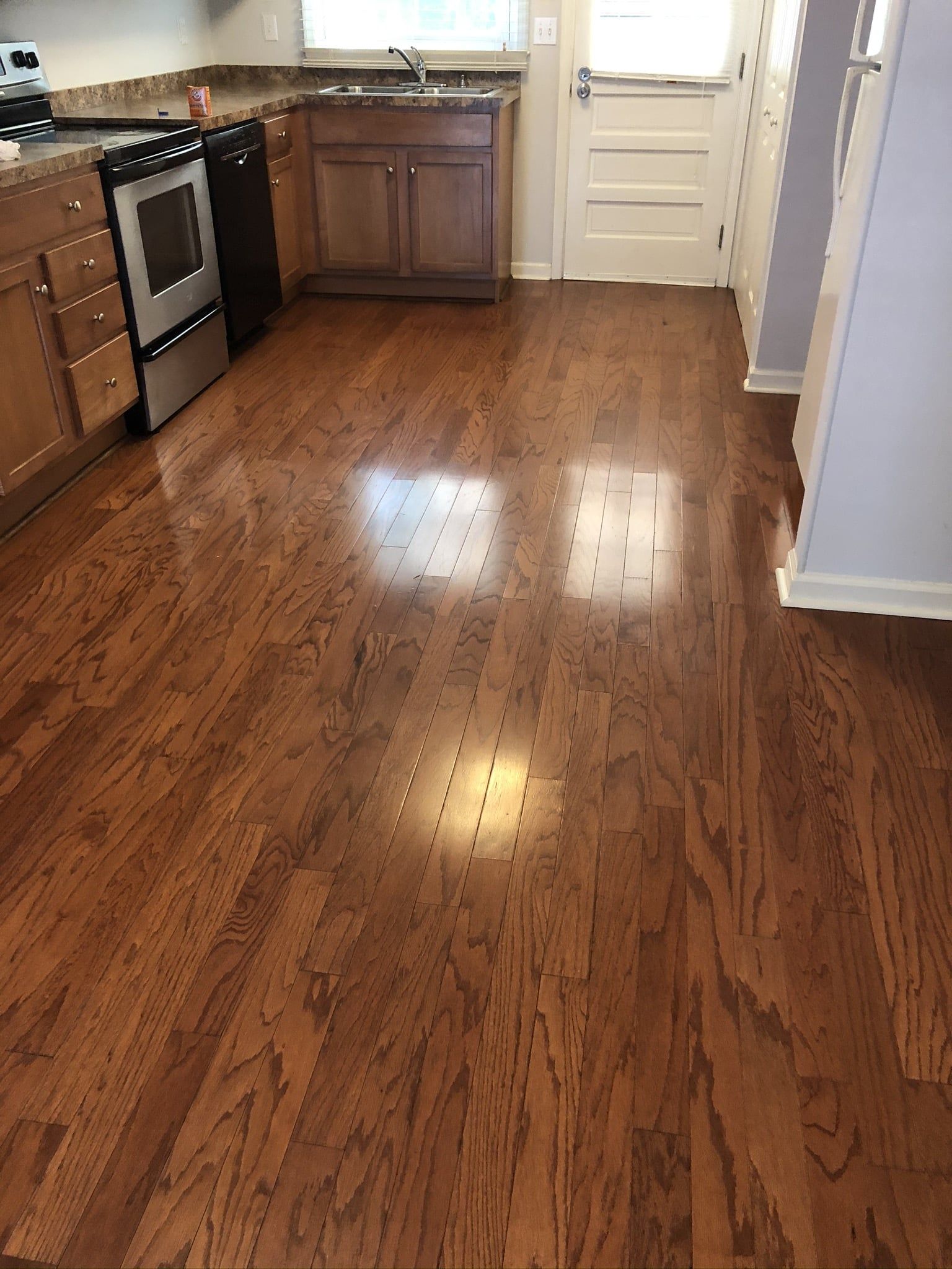 A kitchen with hardwood floors and stainless steel appliances.