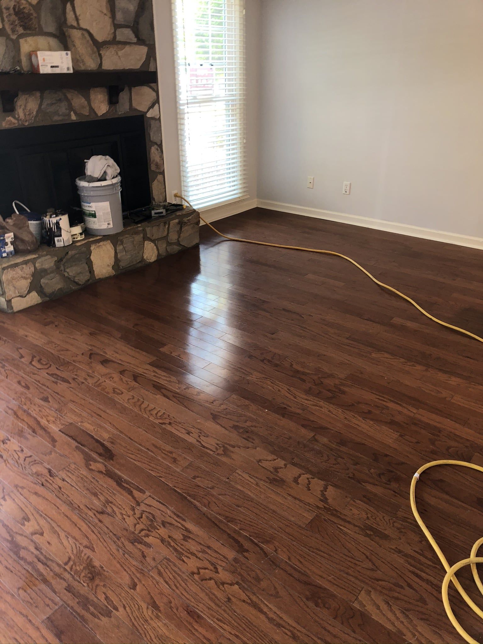 A living room with hardwood floors and a fireplace.