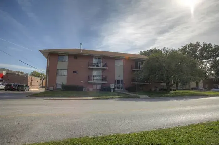 a large brick apartment building is sitting on the corner of a street .