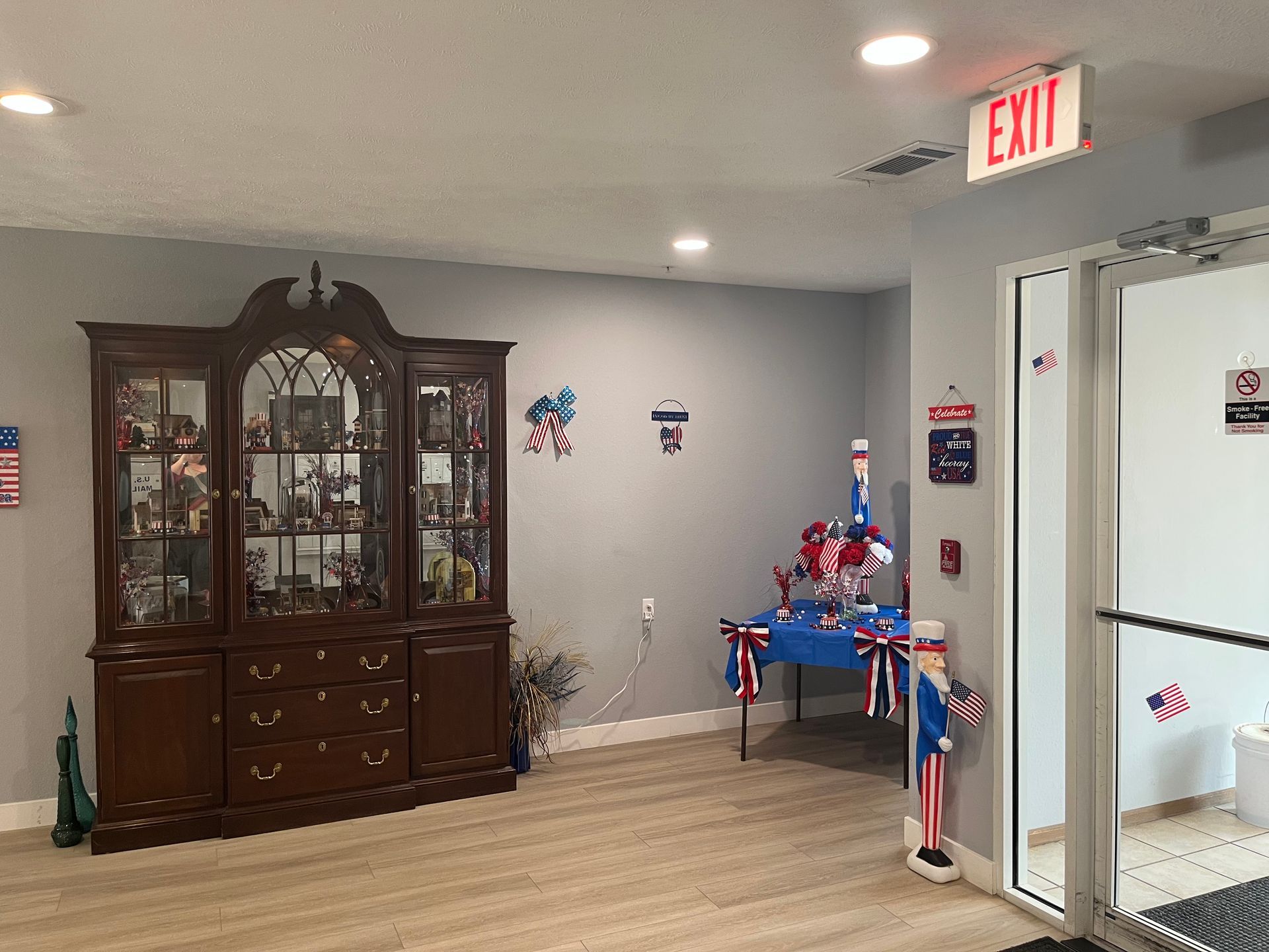 a room with a hutch , table , and exit sign .