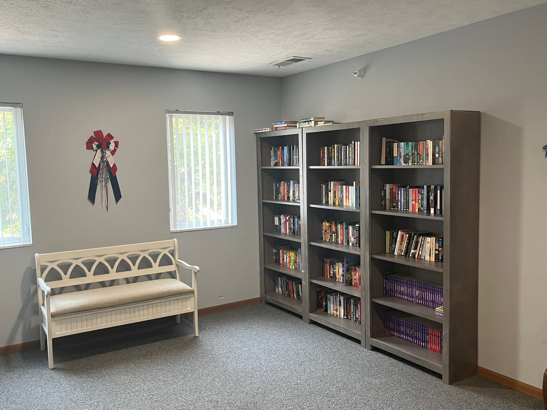 a room with a bench and shelves filled with books .
