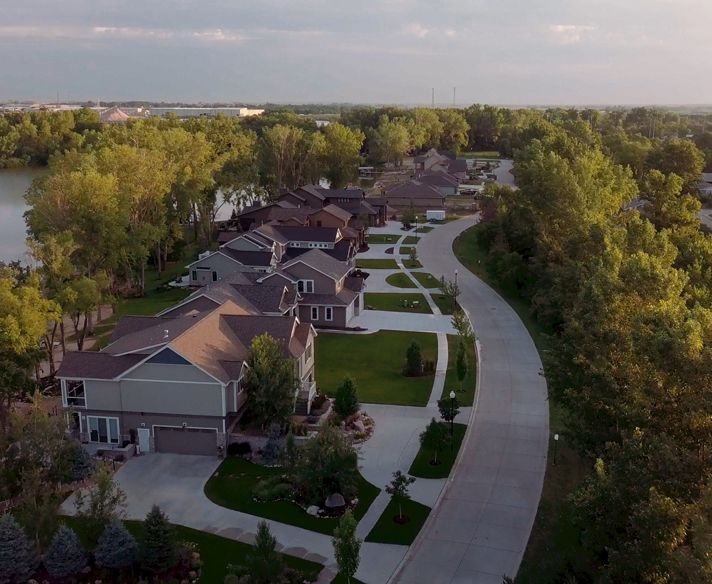 an aerial view of a residential neighborhood with a lake in the background
