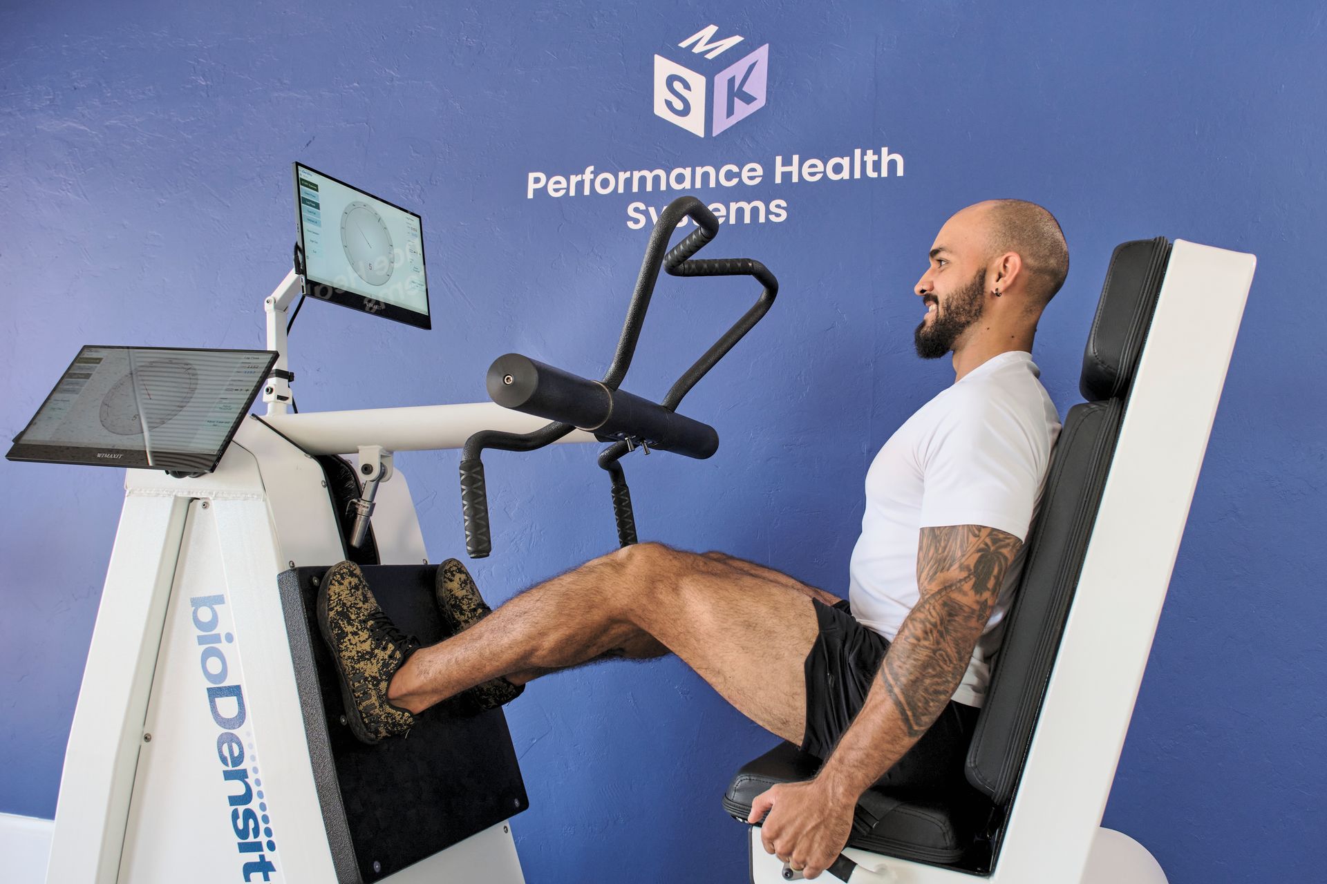 A man is sitting on a machine with his legs crossed.