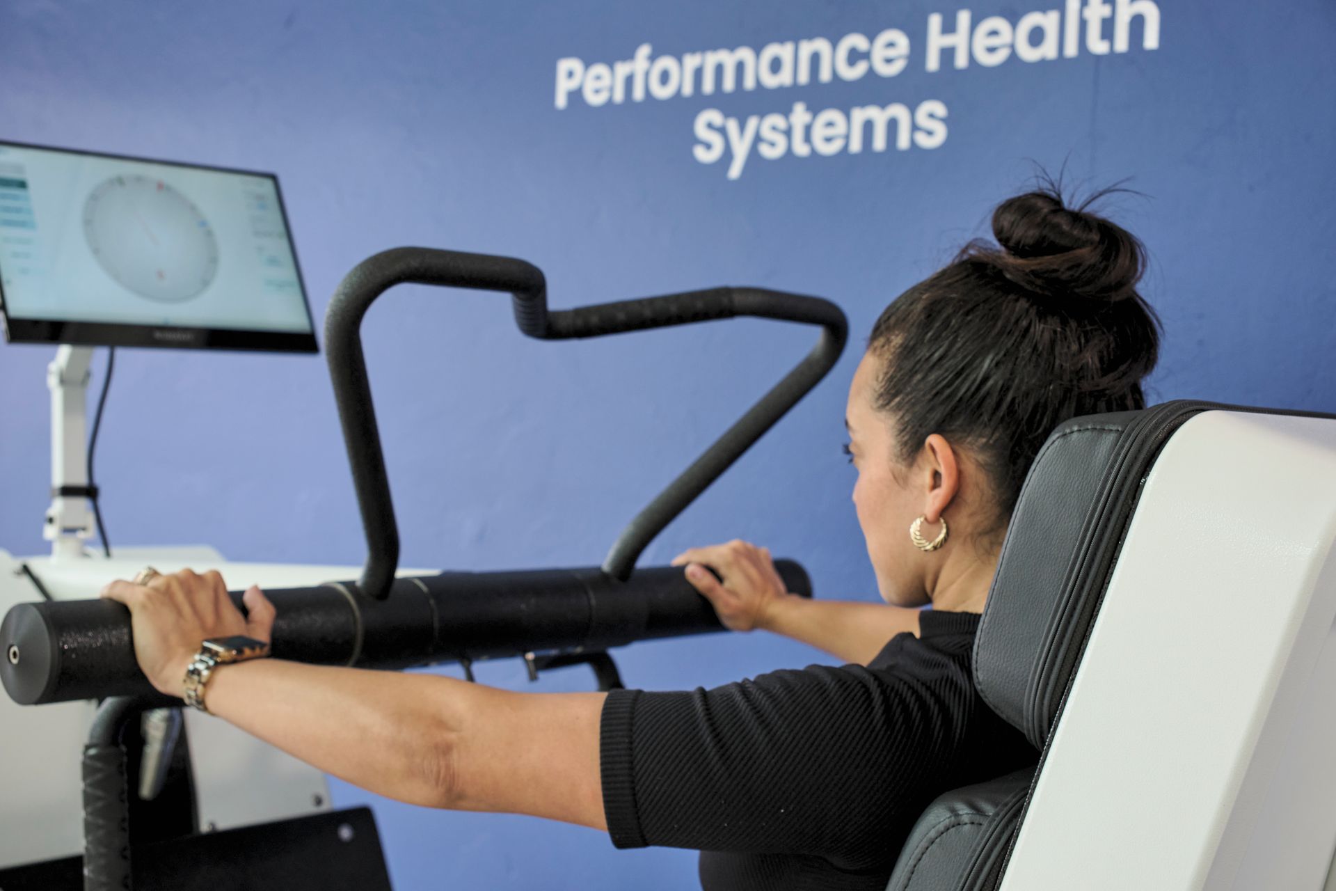 A woman is using a machine that says performance health systems