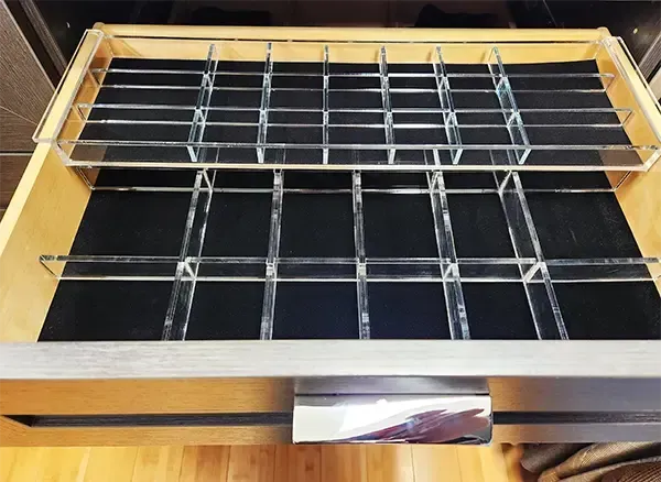 Wooden drawer organizer with metal dividers and a black base insert