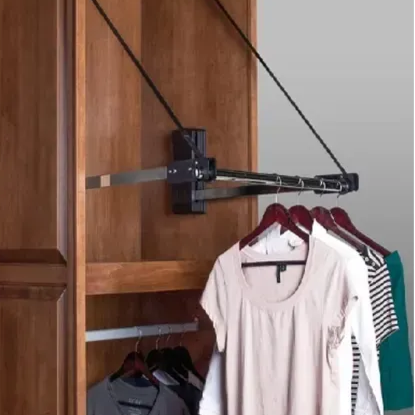 Black folding closet rod extending from wooden wardrobe, holding several hangers with shirts.