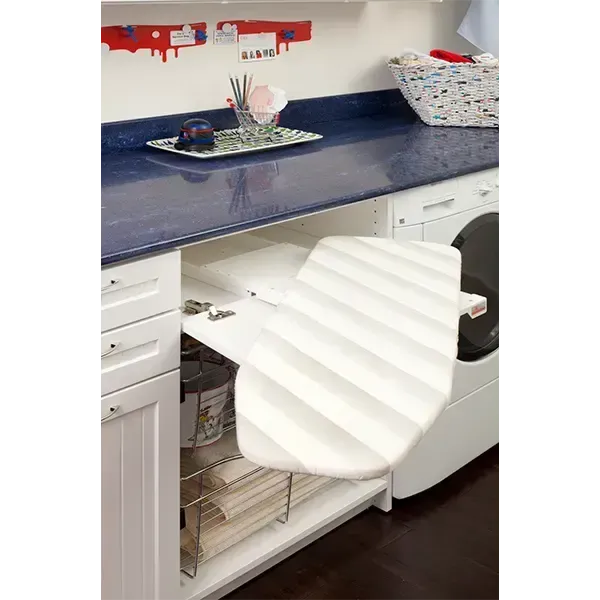 Kitchen countertop with a white chair pulled out and a sink cabinet door open, showing storage baskets inside